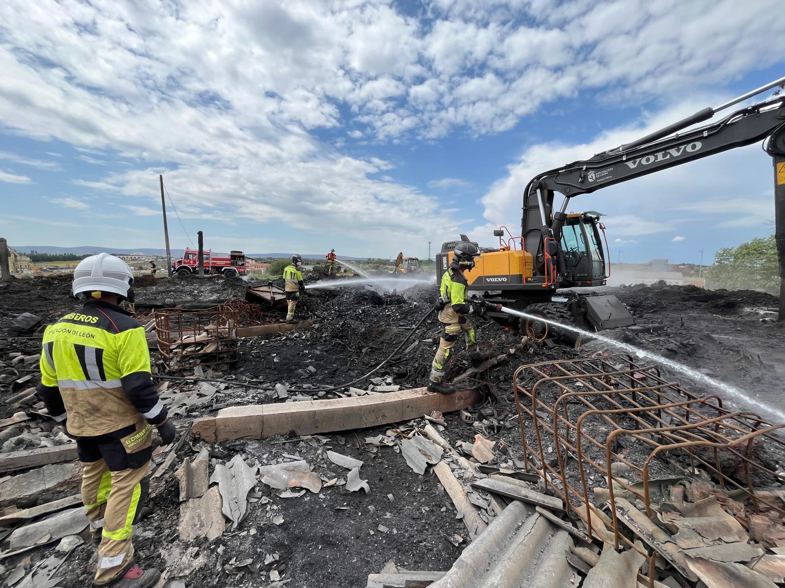 Tres dotaciones de los bomberos de la Diputación de León trabajan en la extinción total del incendio de una nave industrial de La Bañeza